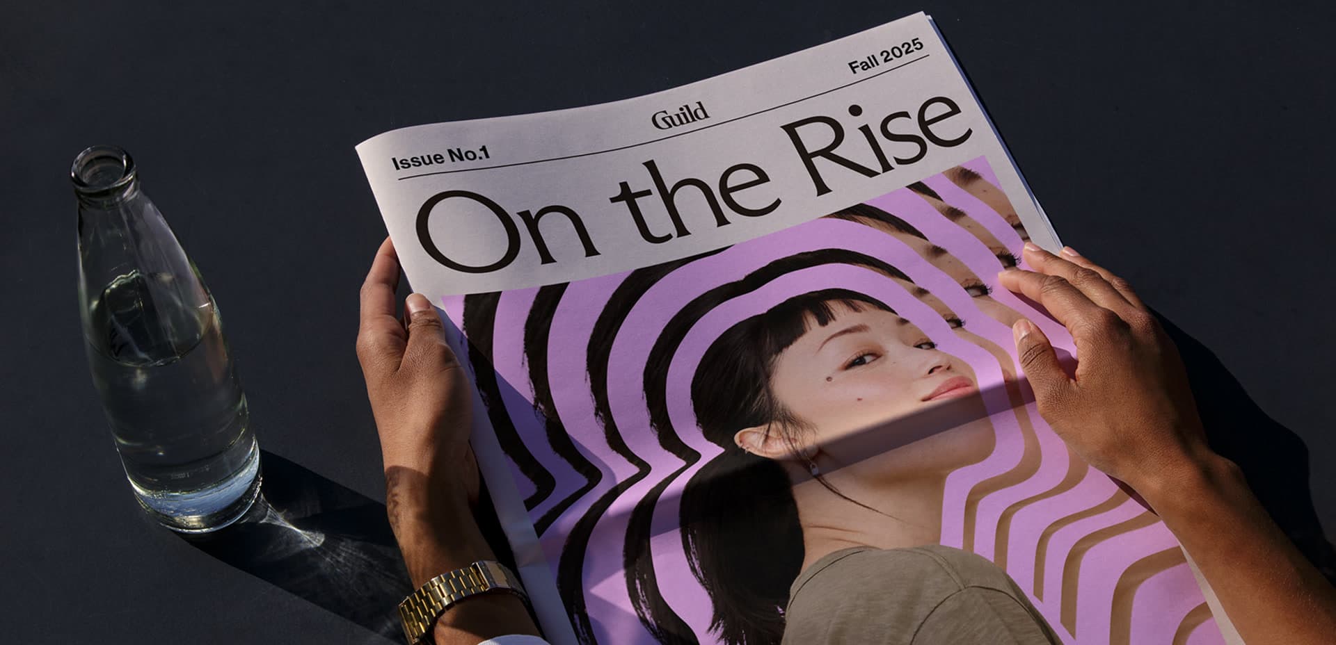 Hands holding a printed copy of the On The Rise newspaper